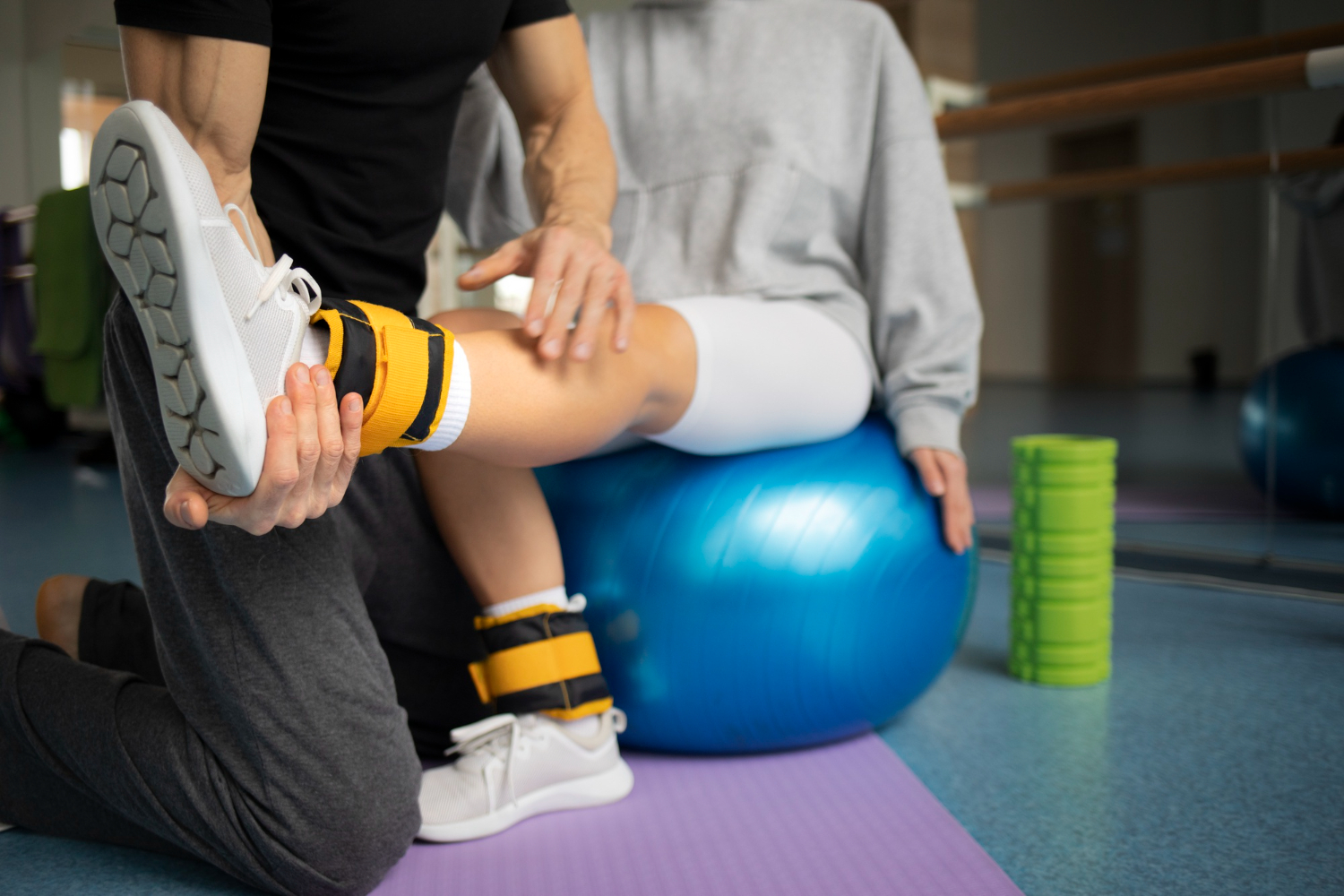 patient sitting on a balance ball at haskell memorial hospital working on physical therapy with a specialist